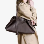Side view of women brown slouchy tote bag, soft leather large shoulder bag worn on shoulder