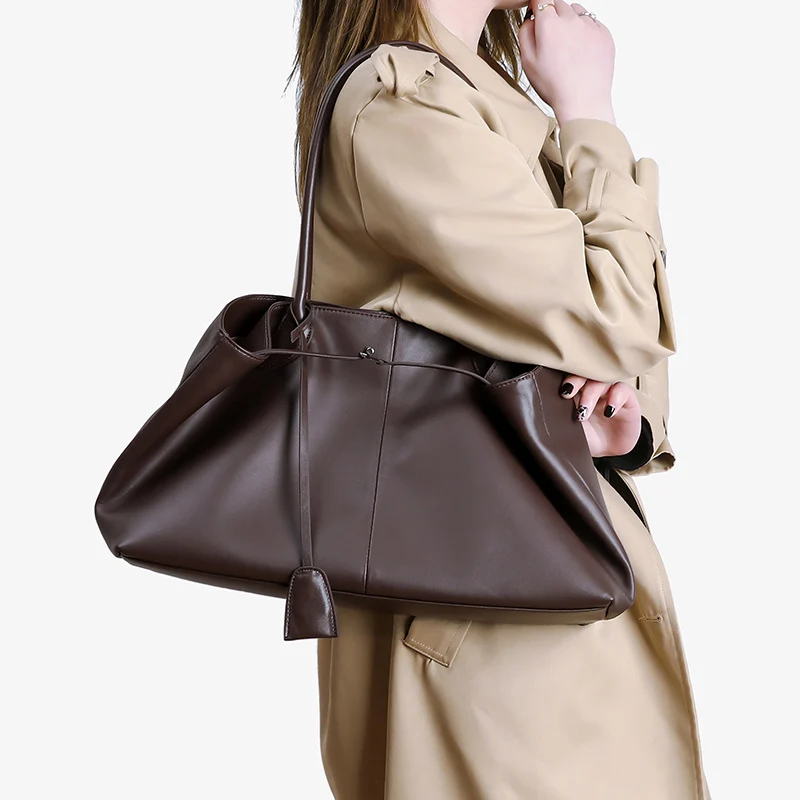 Side view of women brown slouchy tote bag, soft leather large shoulder bag worn on shoulder