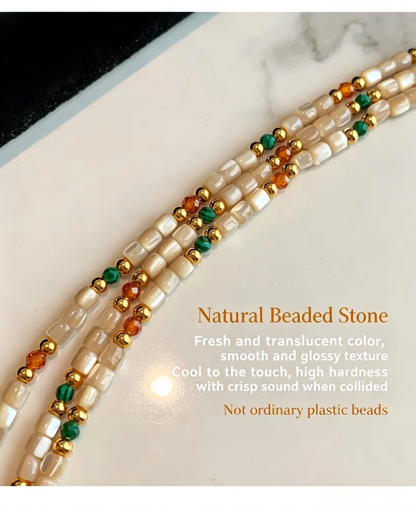 Three strand wrap of the natural stone and shell beaded necklace arranged on a marble surface
