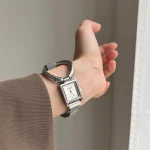 Woman wearing the vintage silver square watch with oversized ring detail and magnetic mesh strap on wrist