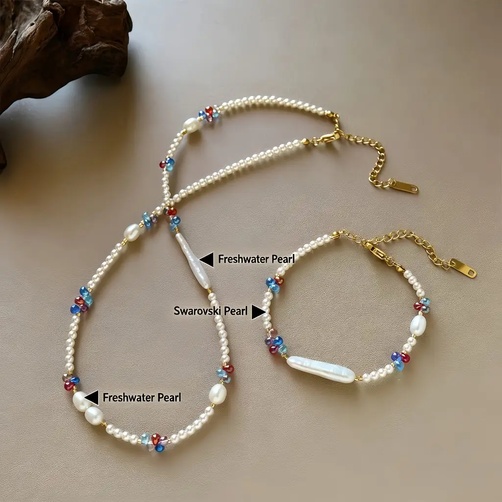 Dopamine freshwater pearl and crystal beaded necklace and bracelet set flat lay with material labels showing Freshwater Pearl and Swarovski Pearl, featuring baroque and biwa pearls, cobalt blue ruby red soft pink crystal beads, and gold-toned hardware on warm taupe background by MAISON ELARA & CO