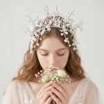 GBride wearing pearl flower wedding headband holding white flower, soft romantic bridal portrait