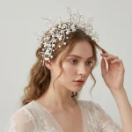 Side view portrait of bride model with pearl flower rhinestone headband, wavy bridal hair