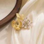 Vintage gold floral crystal hair clip placed on soft cream silk fabric