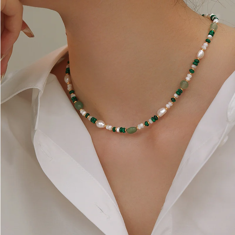 Editorial fashion image of model wearing natural freshwater pearl and crystal beaded necklace and bracelet set, featuring baroque pearls, malachite, aventurine, and 18K gold-plated design with light luxury aesthetic by MAISON ELARA & CO